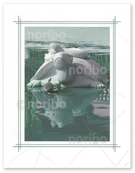 Photo of statue, tortoise and snake, on calm water with reflexion and real turtles on top of and front of the statue.